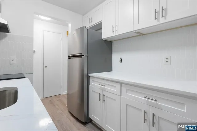 a kitchen with cabinets and a refrigerator