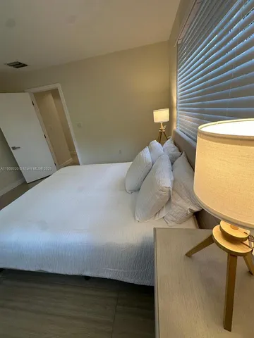 a bedroom with a bed and a potted plant