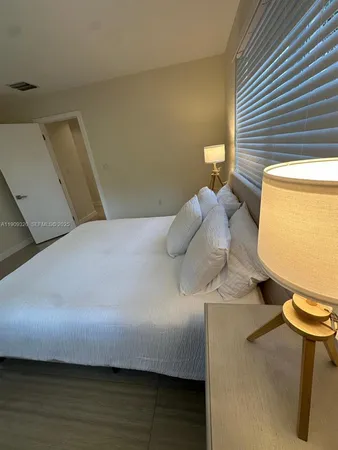 a bedroom with a bed and a potted plant