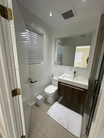 a bathroom with a toilet sink and mirror