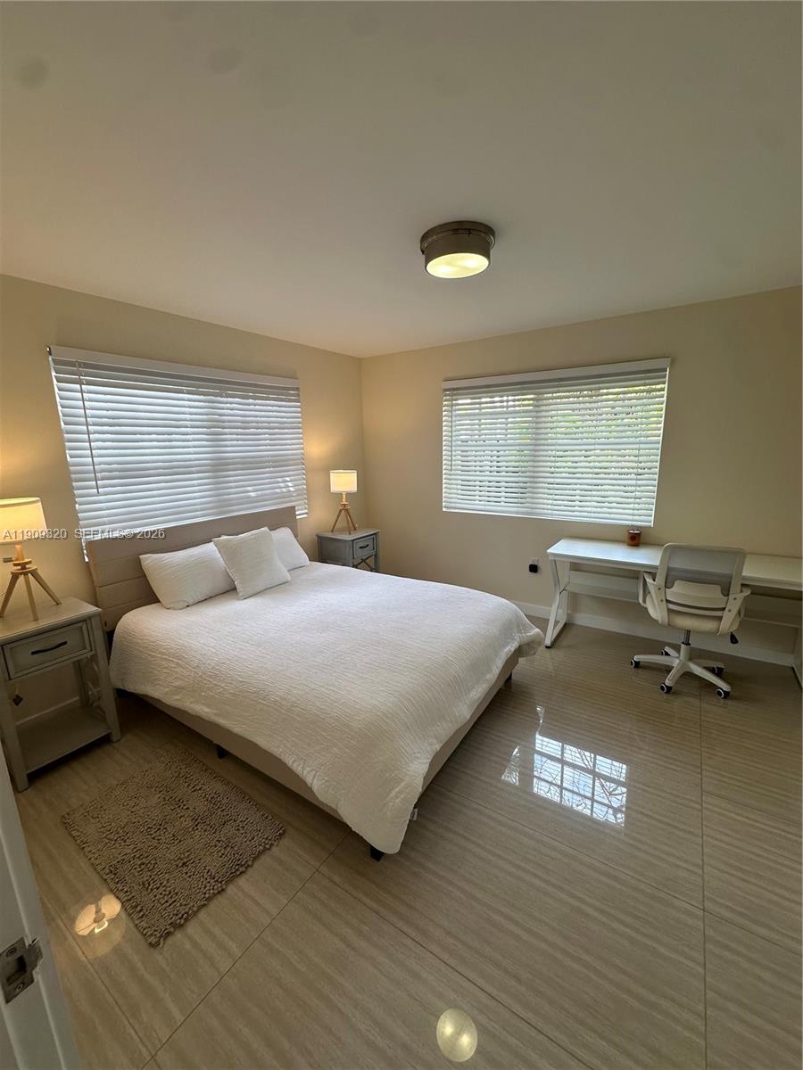 9464 Abbott Avenue Surfside, FL 33154 - Photo 19 of 37 a bedroom with a bed a table and chair