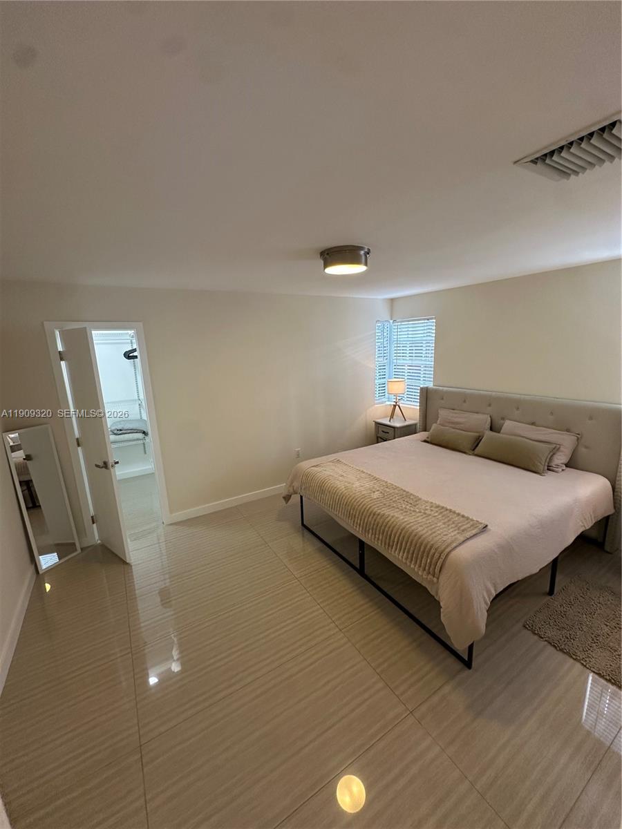 9464 Abbott Avenue Surfside, FL 33154 - Photo 20 of 37 a bedroom with a bed and furniture