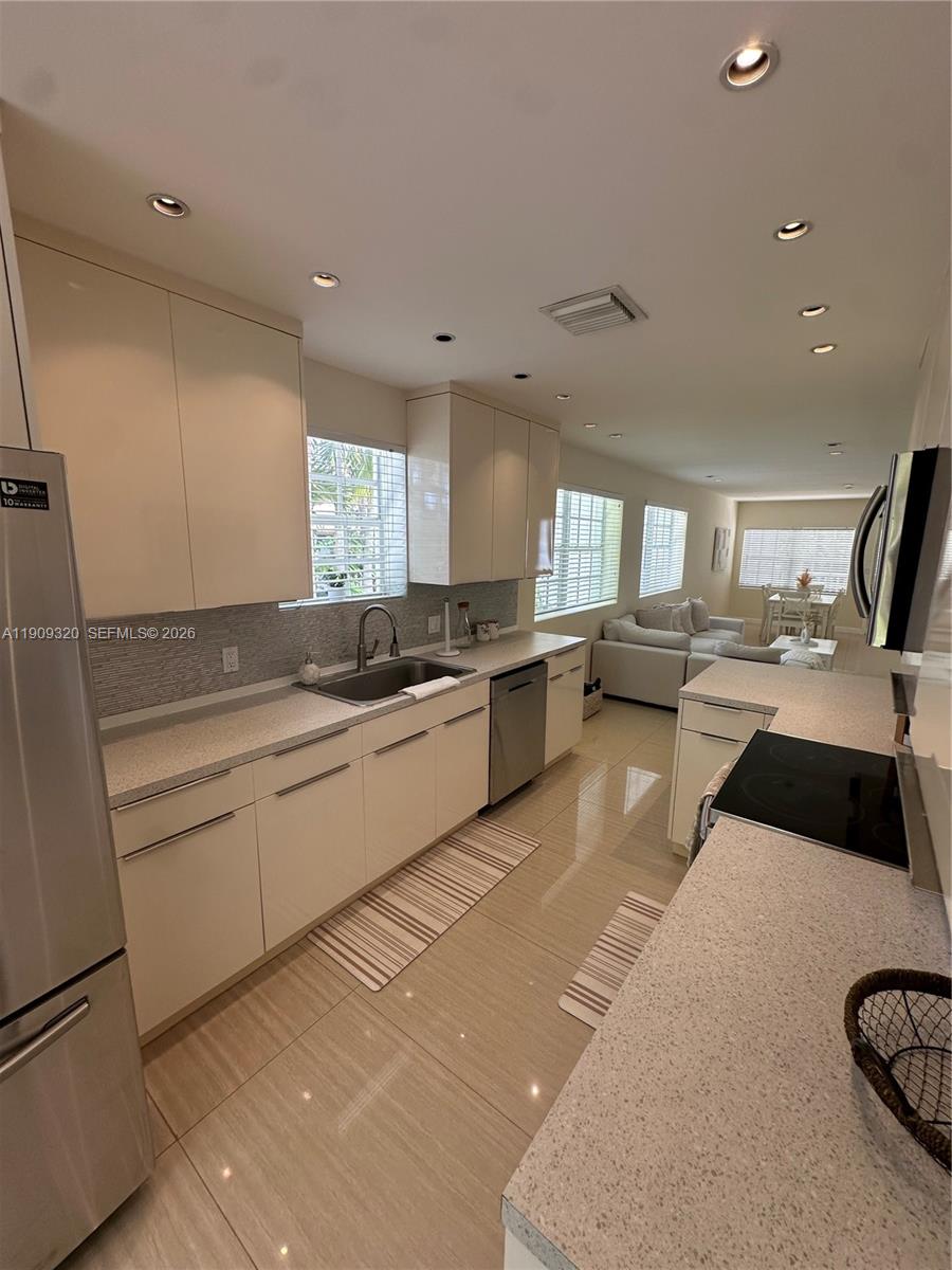 9464 Abbott Avenue Surfside, FL 33154 - Photo 24 of 37 a large white kitchen with a large window