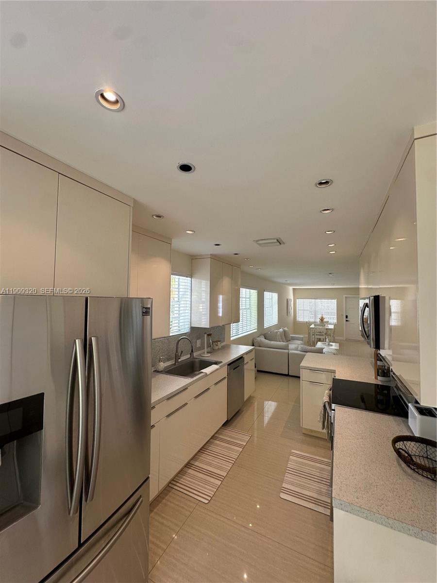 9464 Abbott Avenue Surfside, FL 33154 - Photo 25 of 37 a kitchen with a refrigerator and a stove top oven