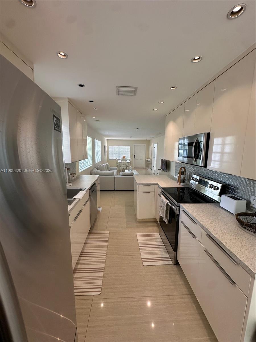 9464 Abbott Avenue Surfside, FL 33154 - Photo 29 of 37 a large white kitchen with stainless steel appliances granite countertop lots of counter top space