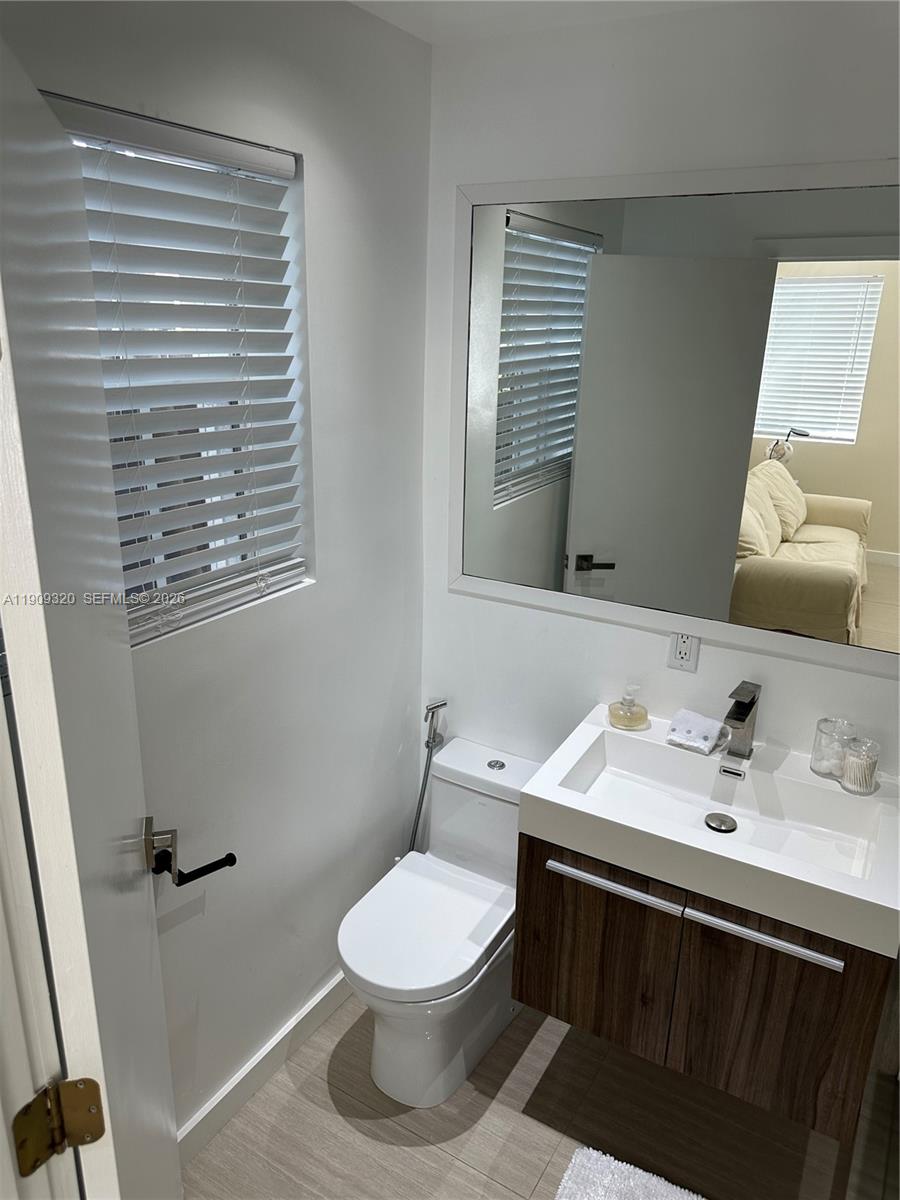 9464 Abbott Avenue Surfside, FL 33154 - Photo 32 of 37 a bathroom with a sink vanity mirror and toilet