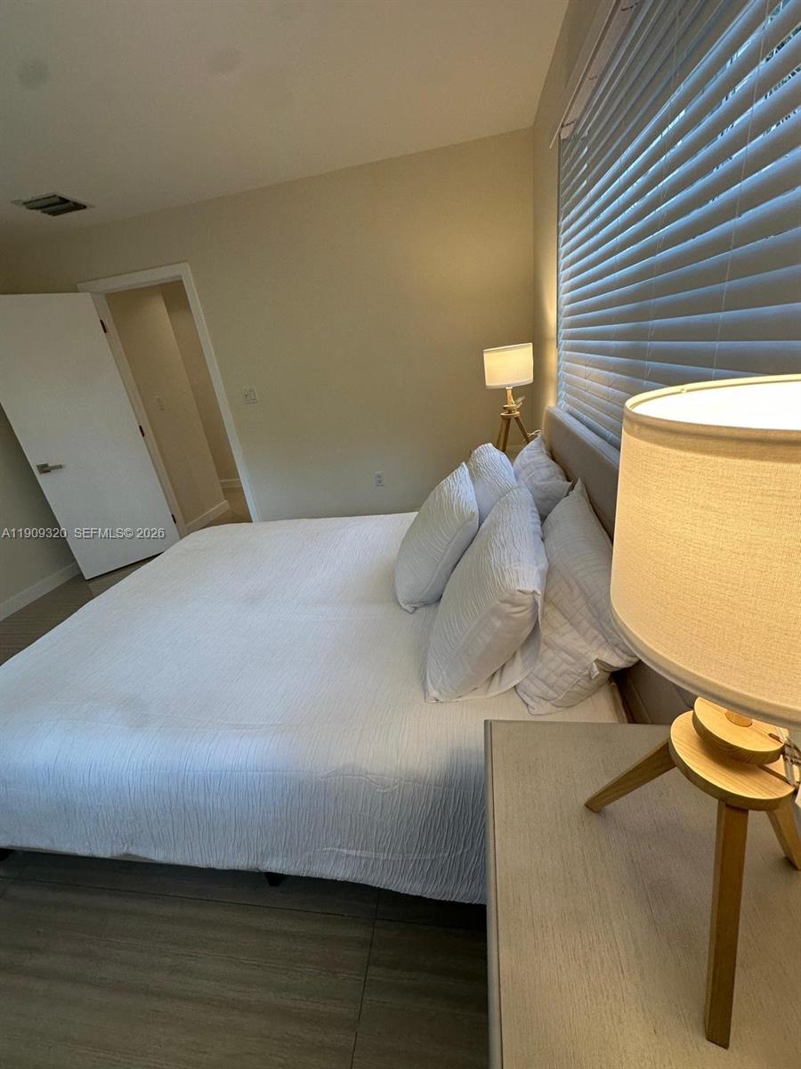 9464 Abbott Avenue Surfside, FL 33154 - Photo 10 of 37 a bedroom with a bed and a potted plant