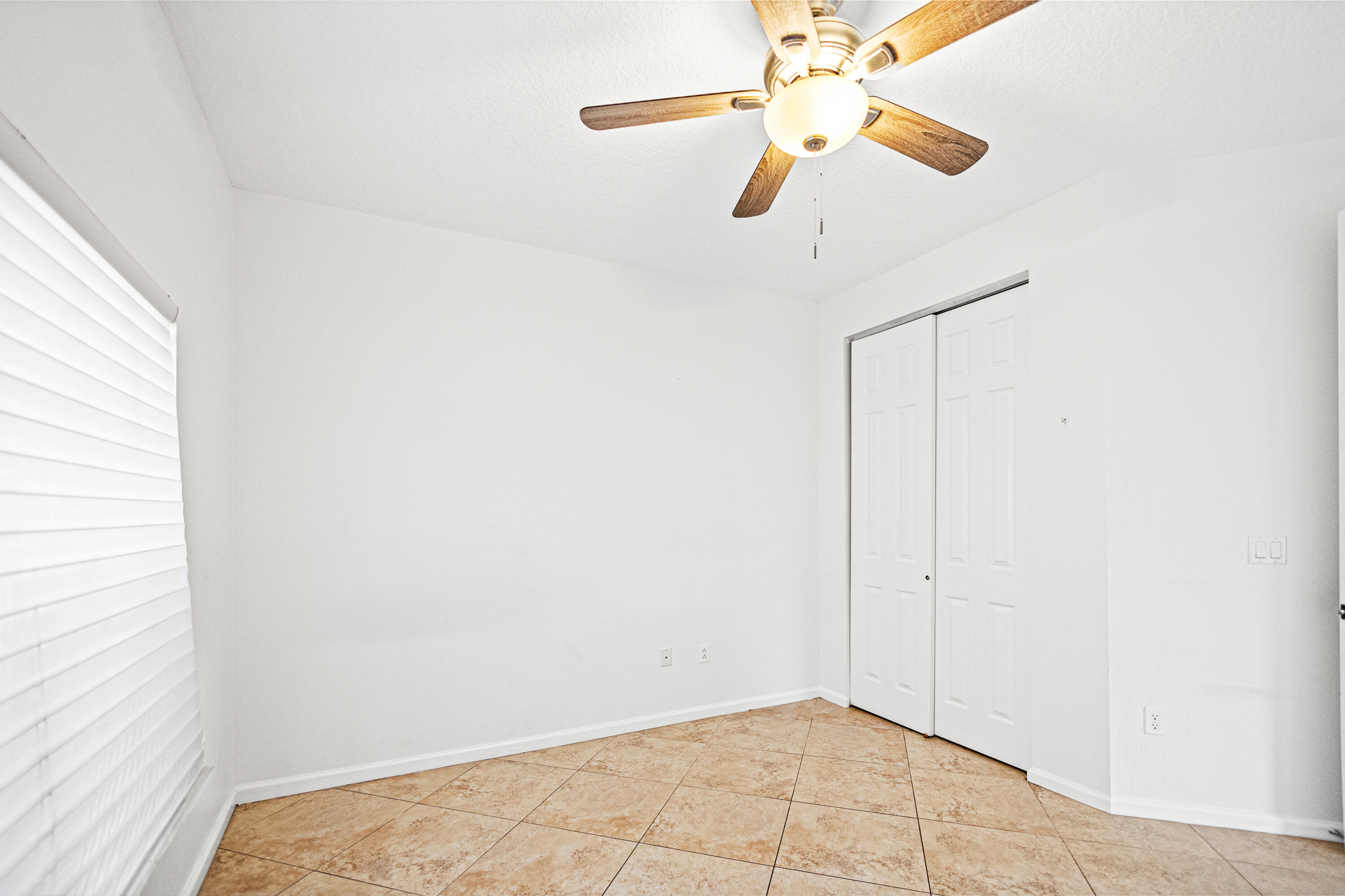 6684 Eagle Ridge Drive Greenacres, FL 33413 - Photo 16 of 27 an empty room with a window and a fan