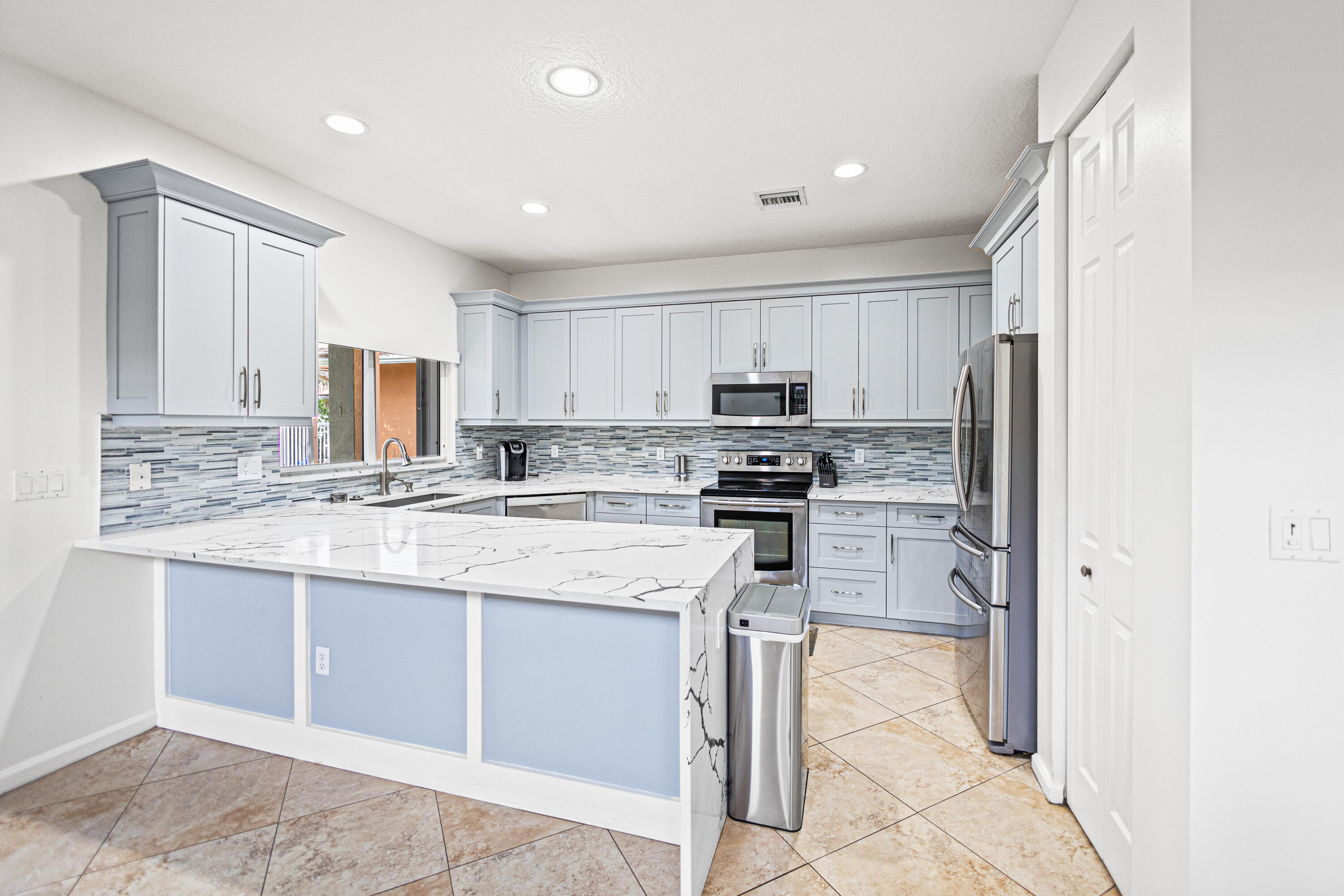 6684 Eagle Ridge Drive Greenacres, FL 33413 - Photo 3 of 27 a kitchen with stainless steel appliances granite countertop a refrigerator sink and cabinets