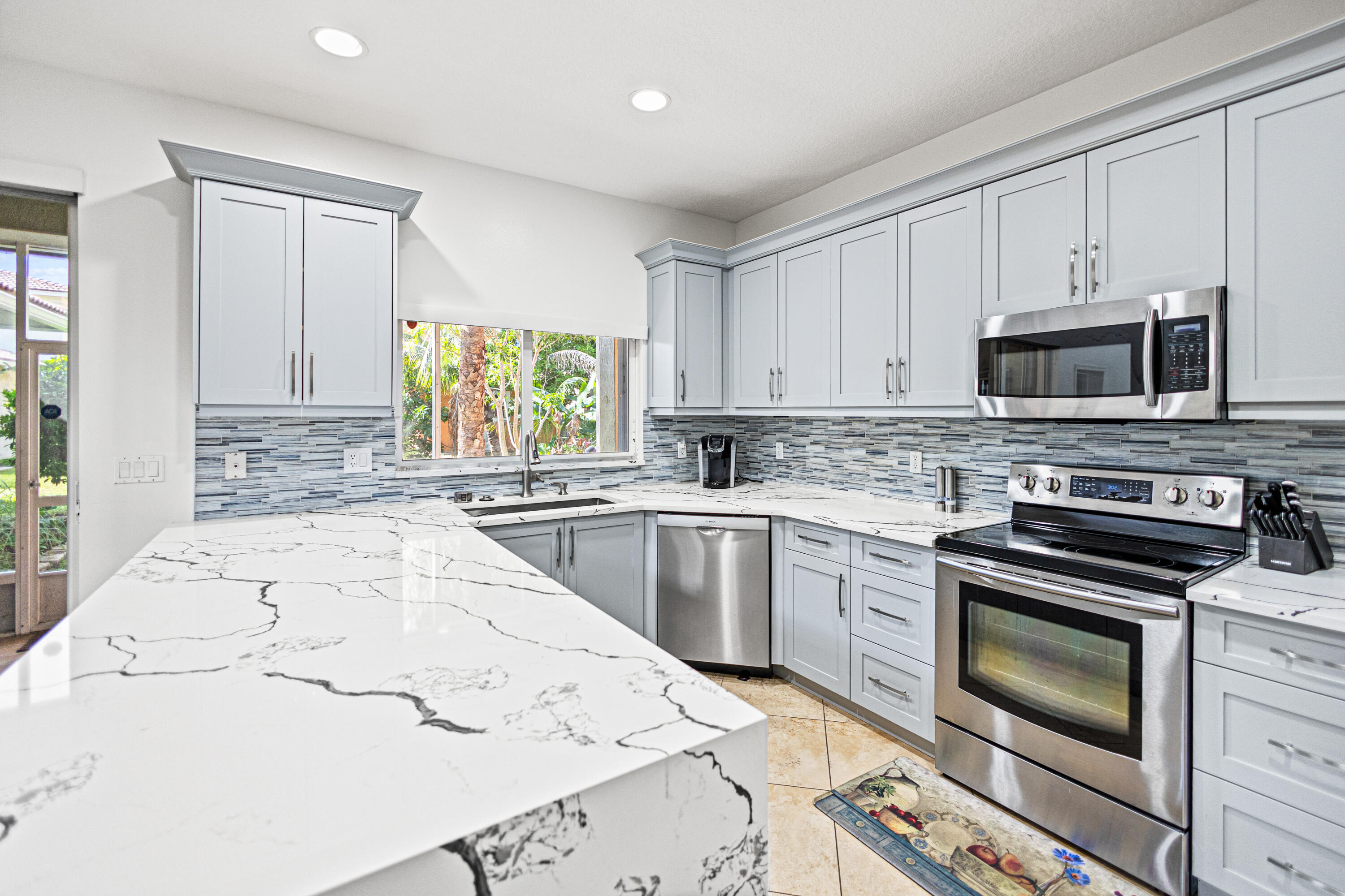 6684 Eagle Ridge Drive Greenacres, FL 33413 - Photo 4 of 27 a kitchen with a stove a sink and a microwave