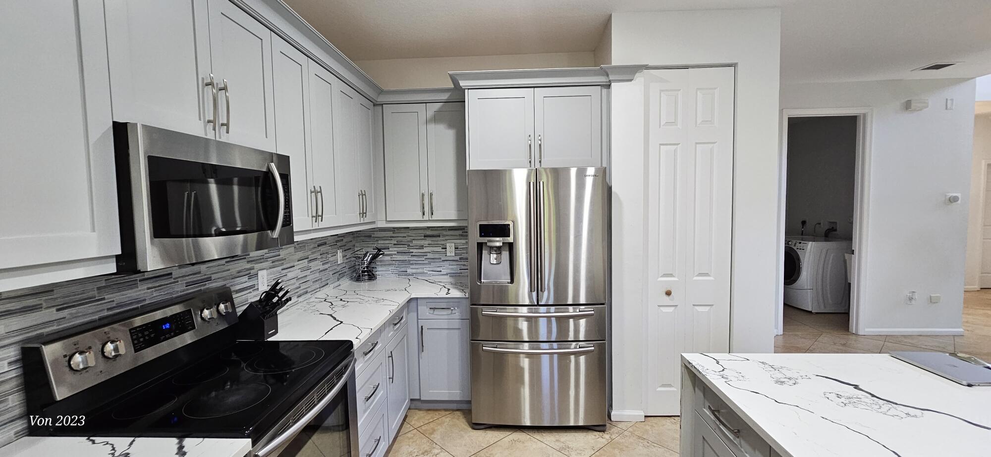 6684 Eagle Ridge Drive Greenacres, FL 33413 - Photo 5 of 27 a kitchen with a refrigerator stove and cabinets