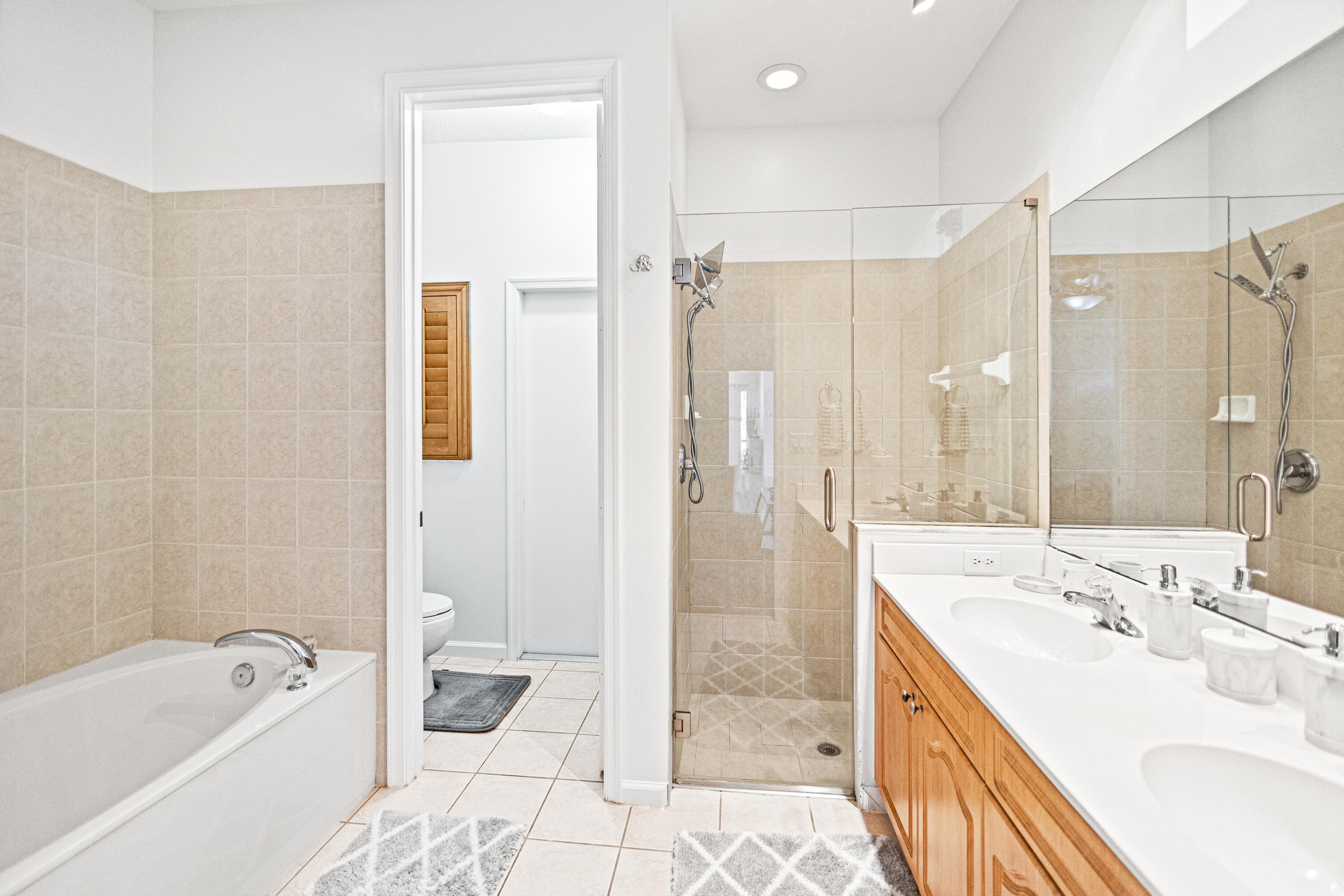 6684 Eagle Ridge Drive Greenacres, FL 33413 - Photo 7 of 27 a bathroom with a tub sink shower and mirror