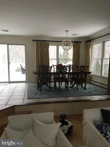 a dining hall with couches a coffee table and chairs with wooden floor