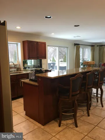 a kitchen with a dining table chairs and large window