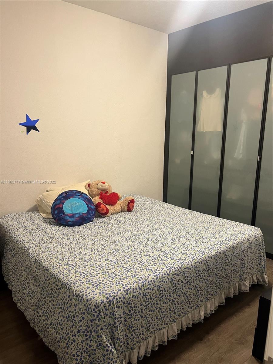 Doral Isles Doral, FL 33178 - Photo 15 of 37 a bedroom with a bed and wooden floor