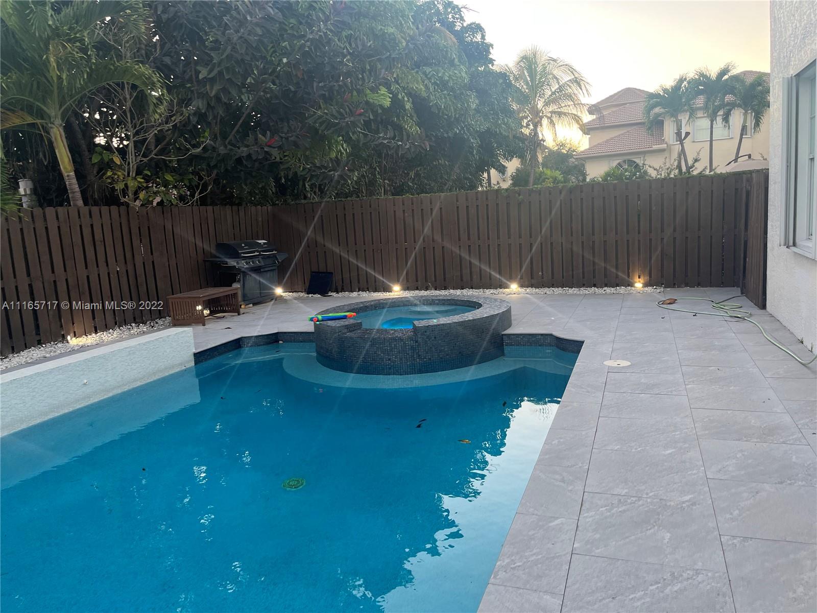 Doral Isles Doral, FL 33178 - Photo 29 of 37 a backyard of a house with table and chairs