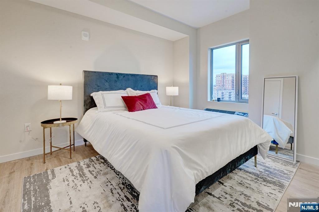 69 Main Street, Unit 1115 Fort Lee, NJ 07024 - Photo 11 of 13 a bedroom with a bed and a night stand