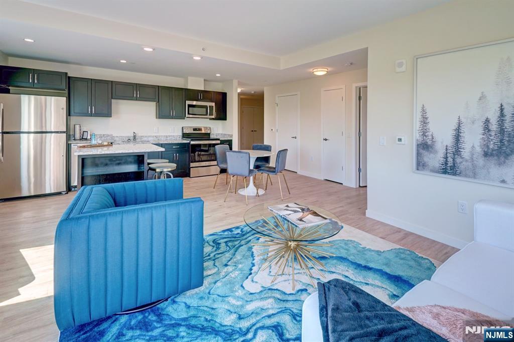 69 Main Street, Unit 1115 Fort Lee, NJ 07024 - Photo 3 of 13 a living room with stainless steel appliances furniture wooden floor and a view of kitchen