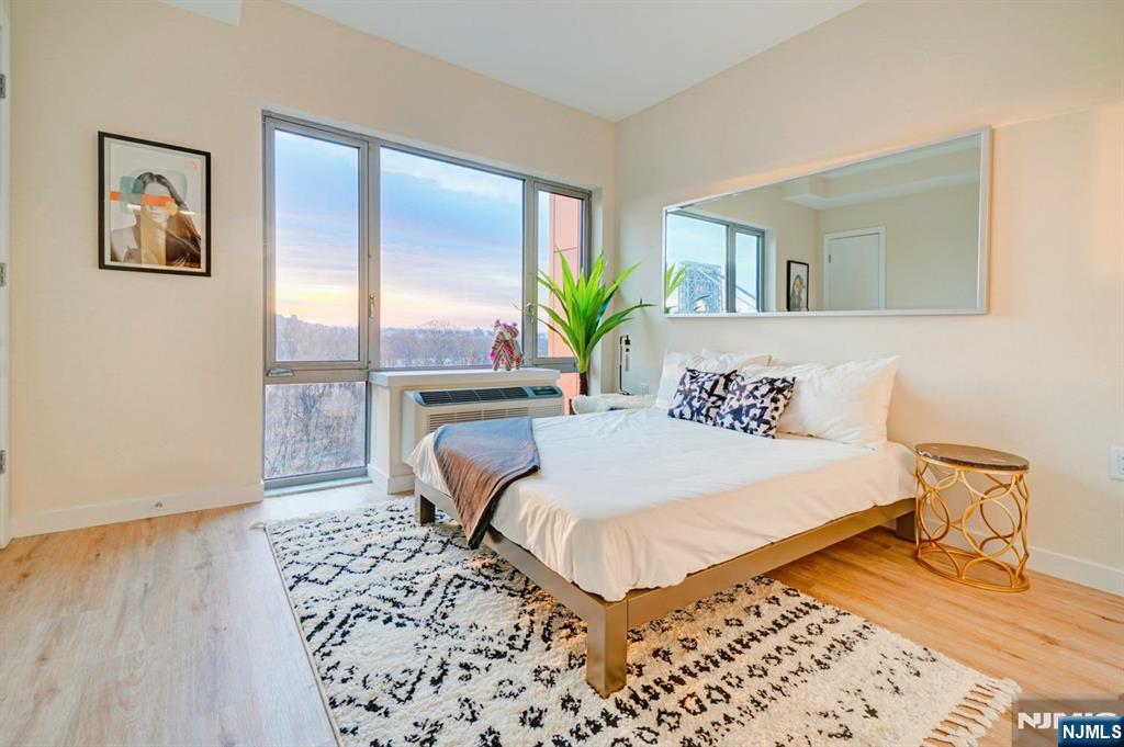 69 Main Street, Unit 1115 Fort Lee, NJ 07024 - Photo 5 of 13 a bedroom with a bed and a painting on the wall