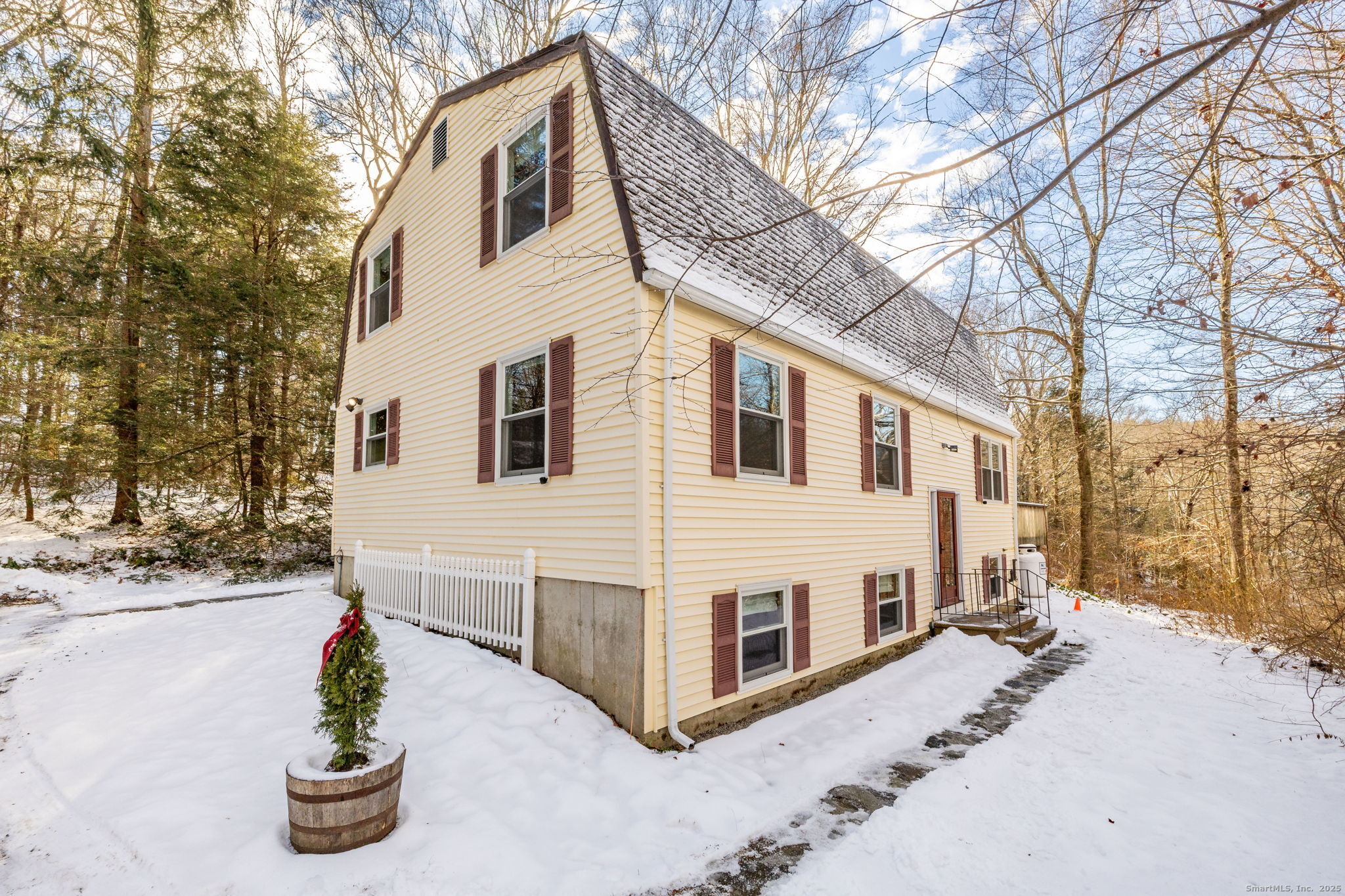 a view of a white house with a yard covered in snow