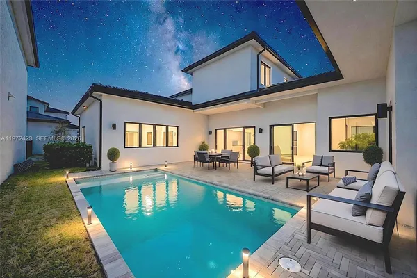 a view of a house with swimming pool and sitting area