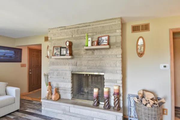 a kitchen with stainless steel appliances granite countertop a refrigerator a stove a sink dishwasher and a dining table with wooden floor