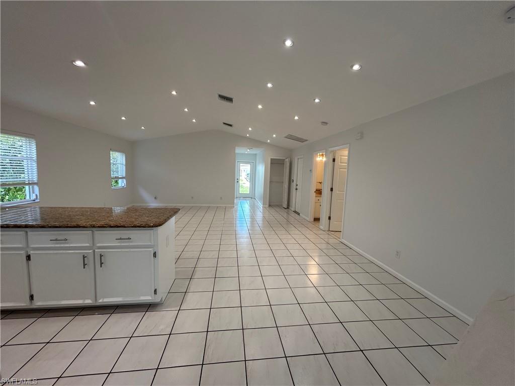 772 100th Avenue North Naples, FL 34108 - Photo 25 of 25 a open kitchen with kitchen island granite countertop lots of white cabinets a granite counter top and a fireplace