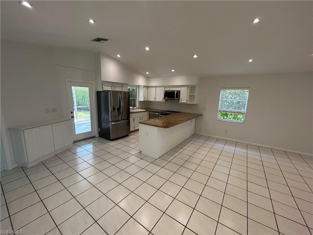 772 100th Avenue North Naples, FL 34108 - Photo 18 of 25 a kitchen with stainless steel appliances a refrigerator and a stove top oven