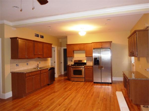 81 Ash Street, Unit 2 Waltham, MA 02453 - Photo 2 of 5 a large kitchen with stainless steel appliances wooden floor and a refrigerator