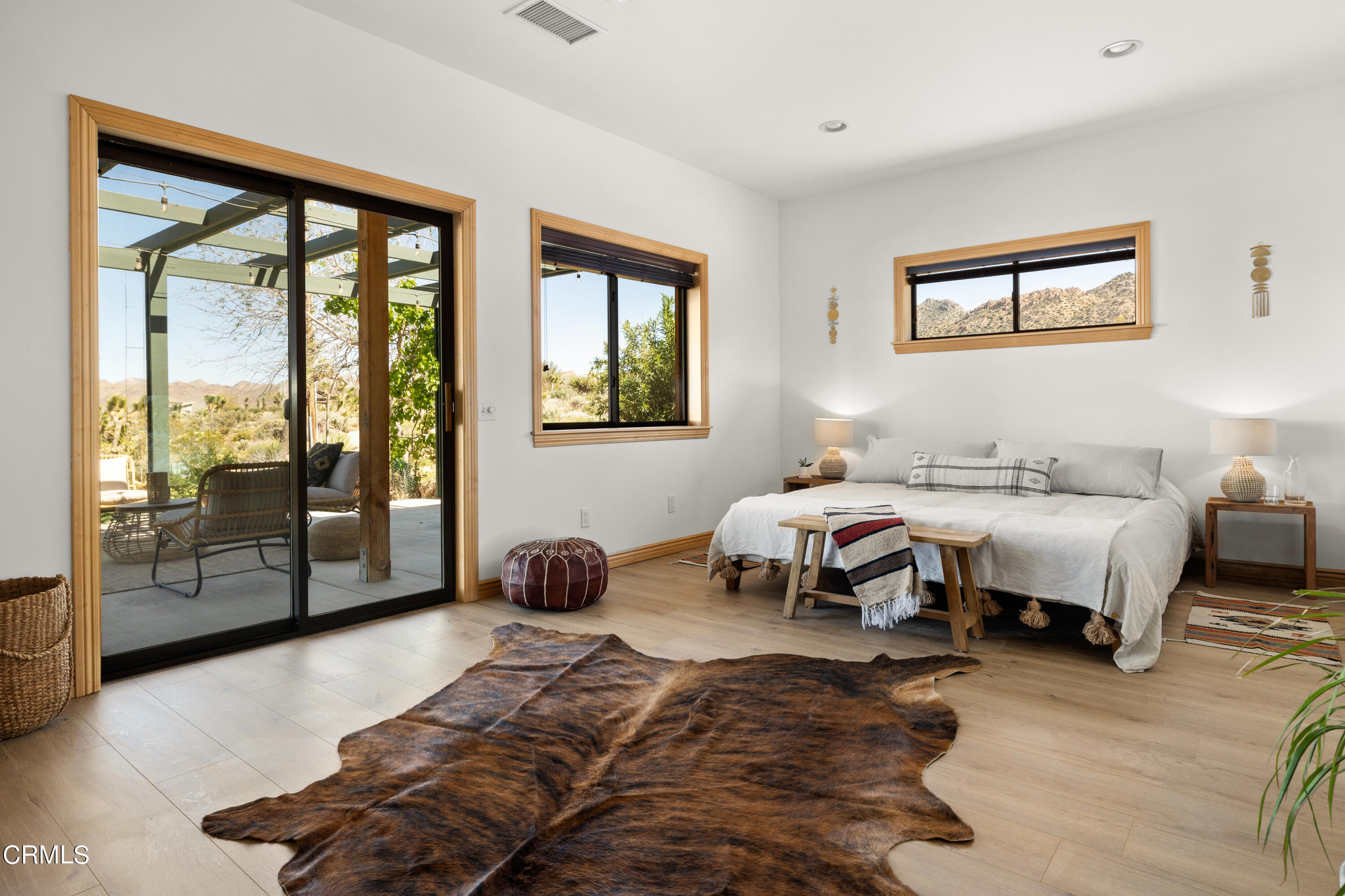 8331 Sunset Road Joshua Tree, CA 92252 - Photo 11 of 58 a spacious bedroom with a bed and glass window