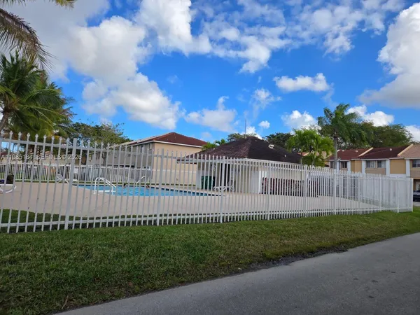 a view of a lake with a big yard and large trees