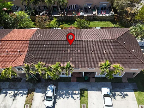 a view of a house with a big yard and large trees