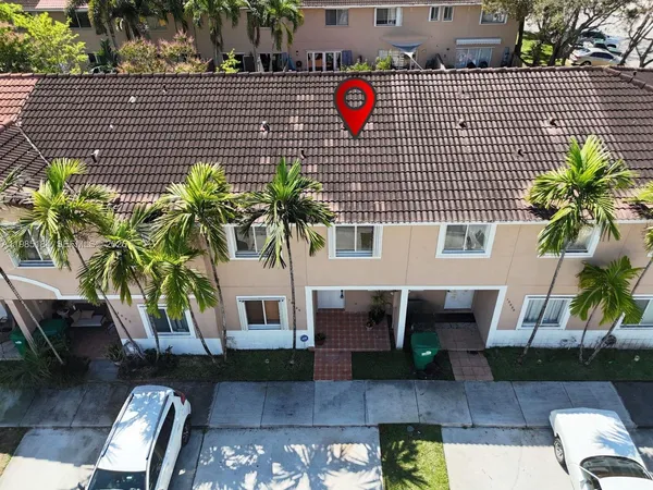 aerial view of a house with a yard and potted plants