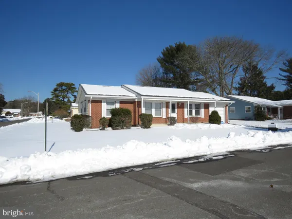 a front view of house with yard covered in snow