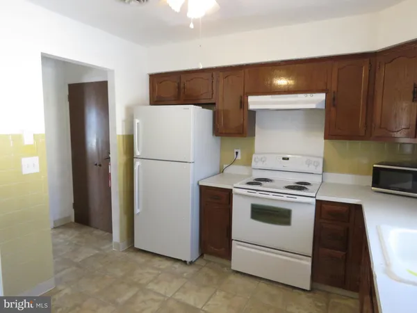 a kitchen with a white stove and refrigerator