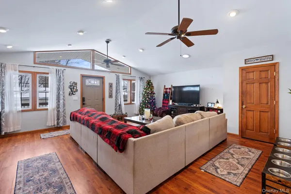 a living room with furniture a flat screen tv and a potted plant
