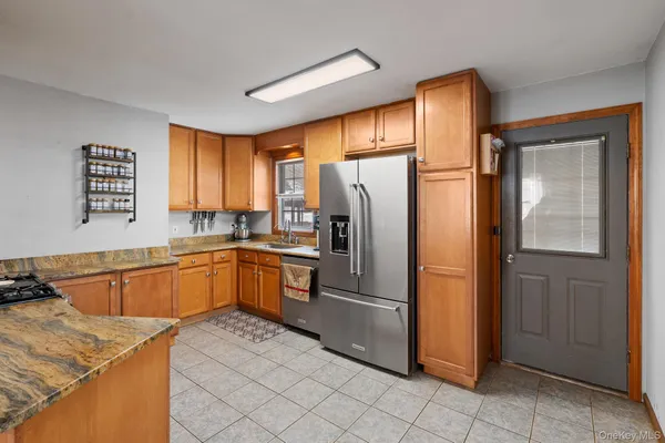 a kitchen with stainless steel appliances granite countertop a refrigerator and a sink
