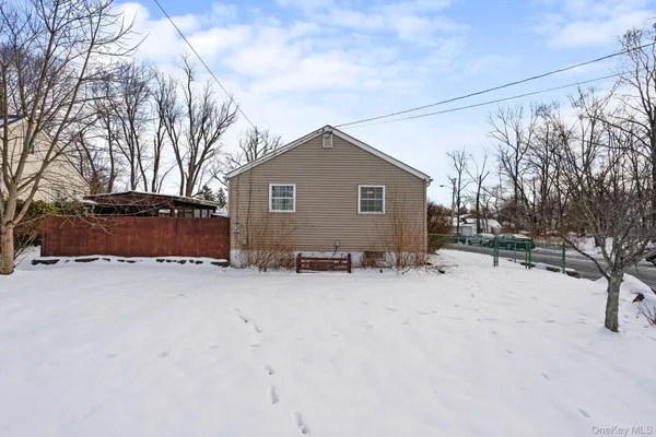 a front view of a house with a yard covered in snow