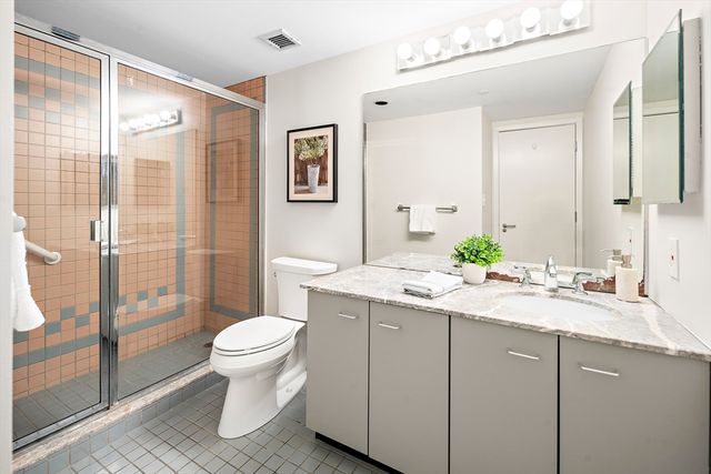 a bathroom with a granite countertop sink toilet and shower