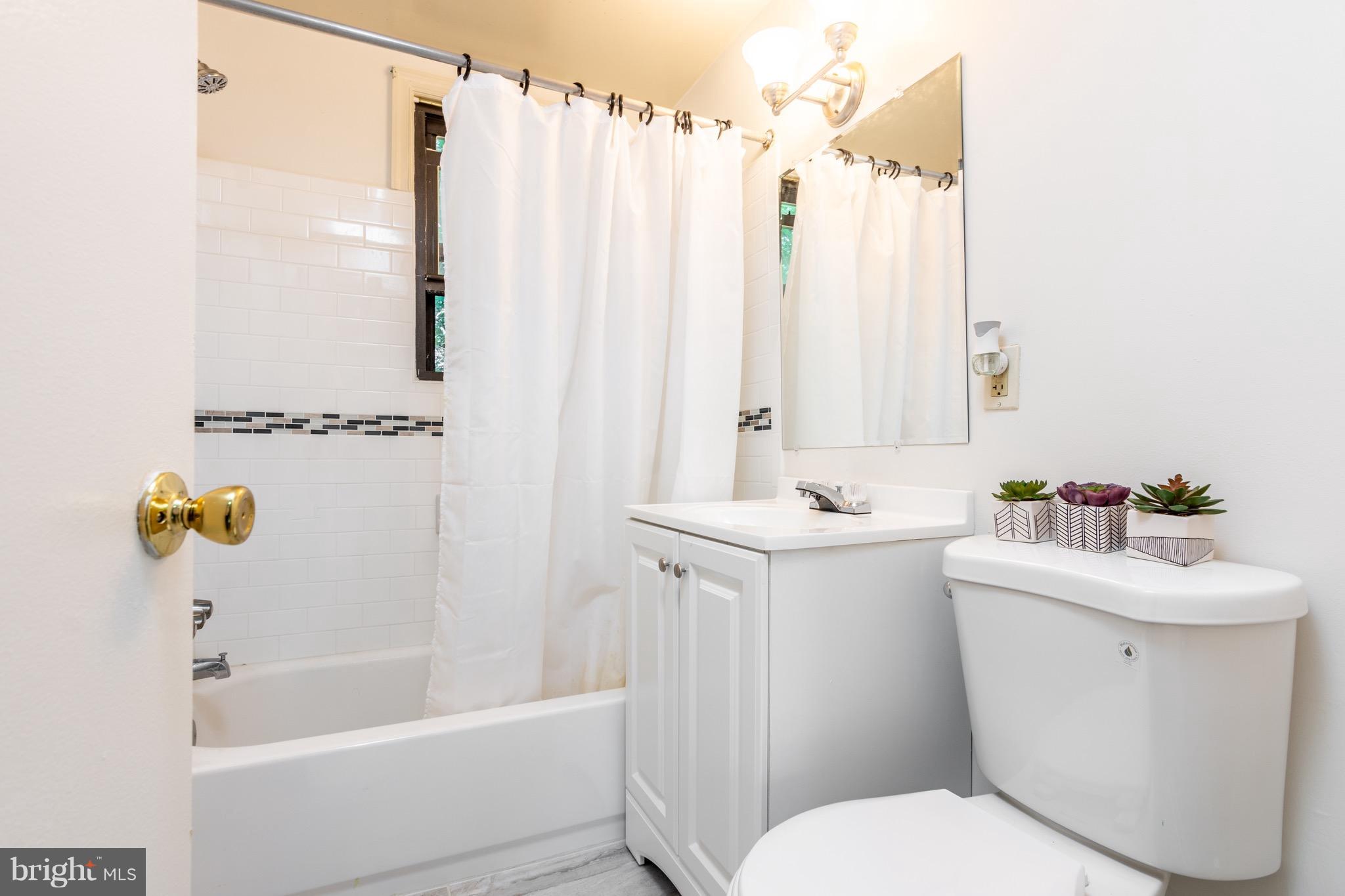5017 Sheriff Road Northeast Washington, DC 20019 - Photo 14 of 22 a bathroom with a sink a toilet and shower