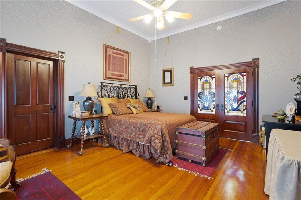 300 West 6th Street Bonham, TX 75418 - Photo 7 of 37 a bedroom with a bed and wooden floor