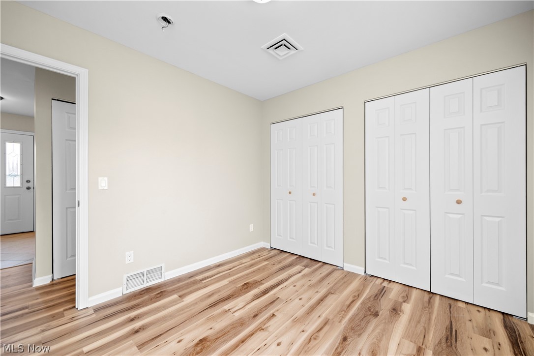 12452 Island Road Grafton, OH 44044 - Photo 24 of 39 Unfurnished bedroom with two closets and light wood finished floors