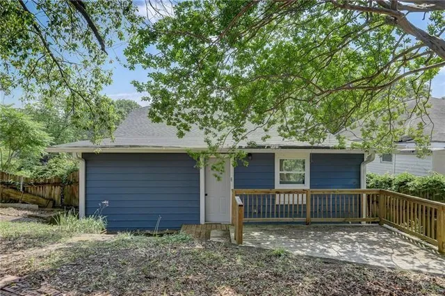 a view of a house with a fence and a tree