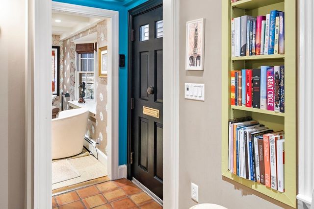 a view of a hallway with wooden floor and a book shelf