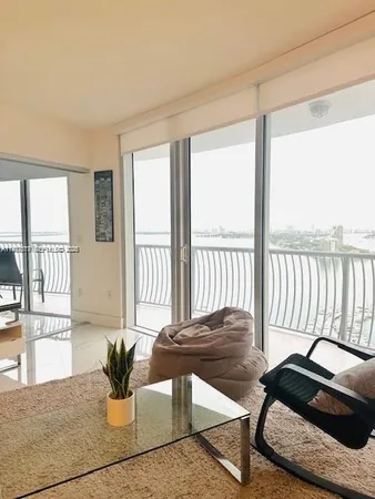 a living room with furniture and floor to ceiling windows