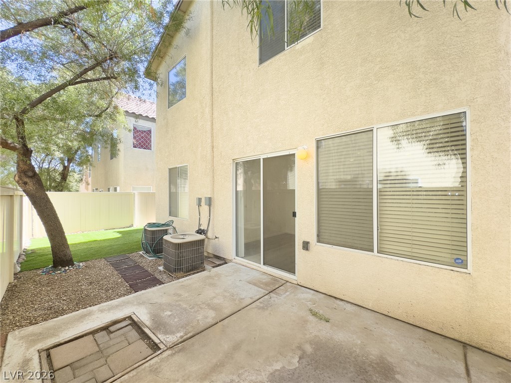 9456 Grandview Spring Avenue Las Vegas, NV 89166 - Photo 40 of 49 A private outdoor space with a paved patio and a lush green lawn offers a serene retreat.