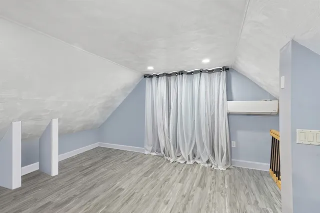 an empty room with wooden floor and a ceiling fan