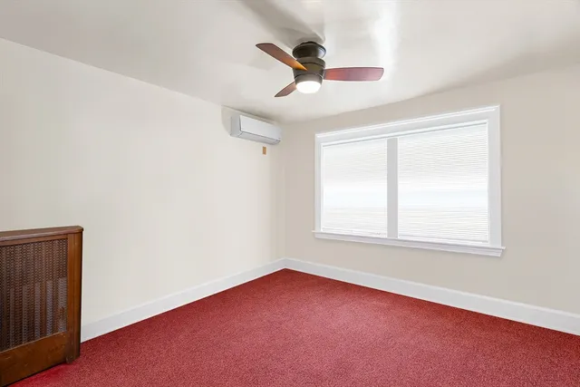 an empty room with a window and a ceiling fan