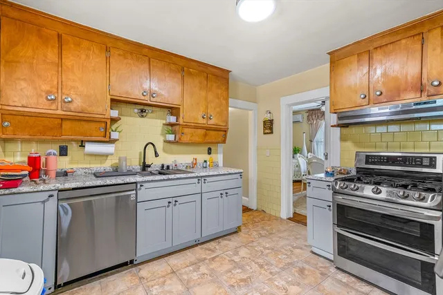 a kitchen with stainless steel appliances a stove a sink and cabinets