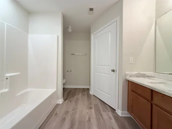 a bathroom with a granite countertop sink a toilet and shower